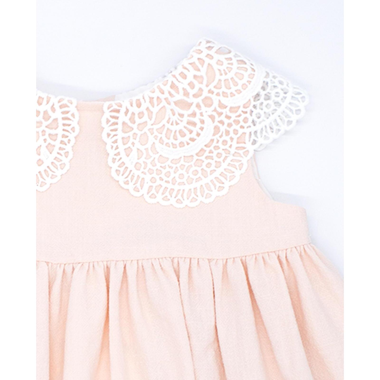 Vestido corto rosa, falda fluncida y cuello de guipur blanco.