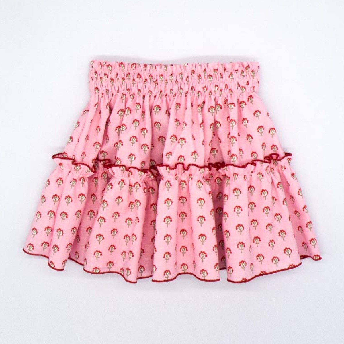 FALDA CON VOLANTE ROSA CON FLORES ROJAS