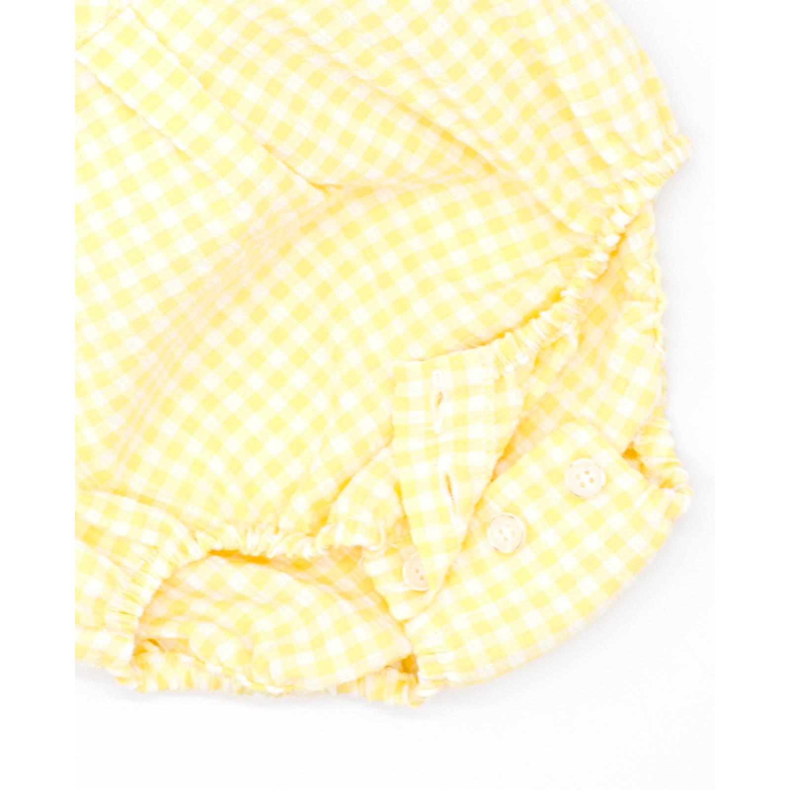 Pelele de vichy amarillo. Con bolsillo y tapeta con botones en el delantero. Goma en las piernas.