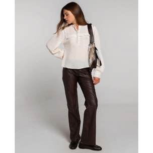 Pantalón de polipiel marrón con bragueta, doble botón y bolsillos.