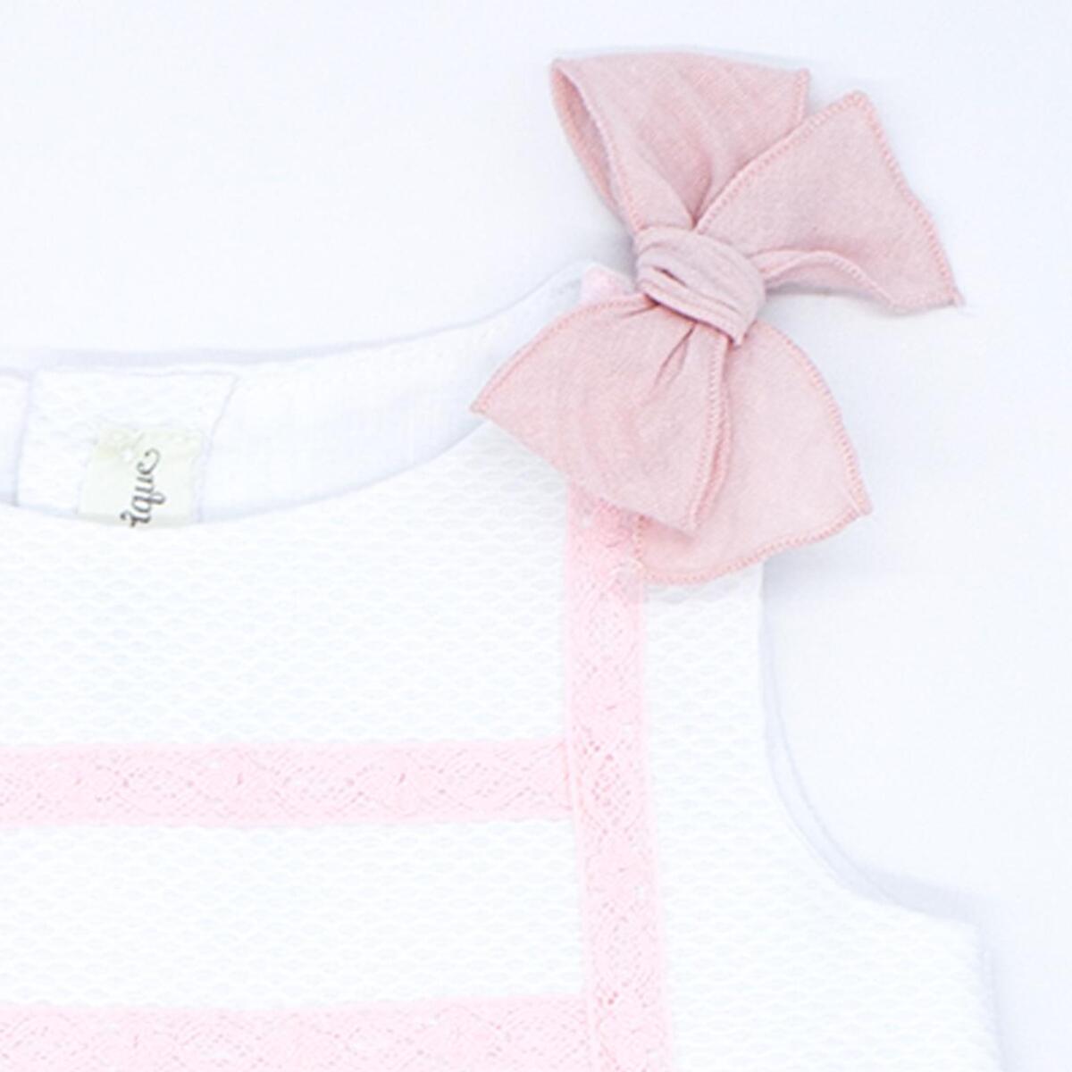 Vestido de piqué blanco con detalle de puntillas rosas.