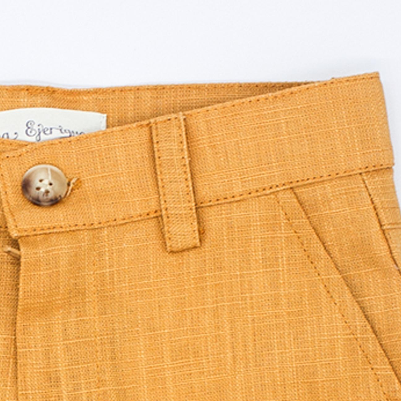 Bermuda de lino mostaza, con bolsillos y bragueta.