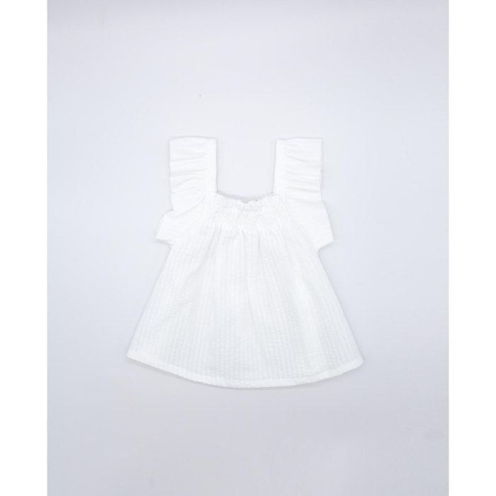 Blusa blanca. Fruncida en la parte superior, con volantes en las sisas.