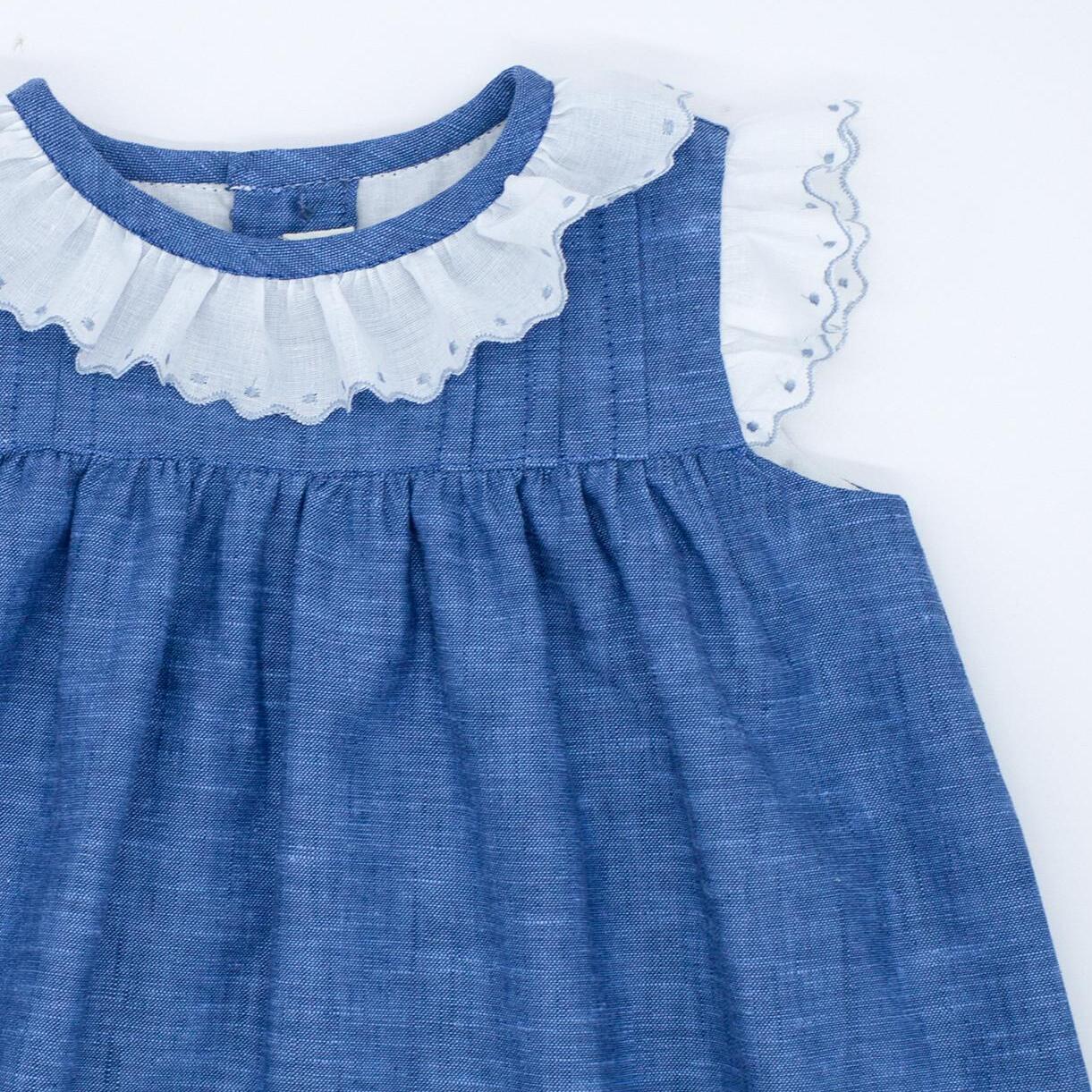 Vestido corto azul, con tira bordada en sisas y cuello, falda fruncida y lorzas en el pecho.