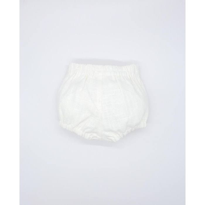 Bermuda de lino blanco. Con botones en el centro, goma en la cintura y en las piernas.