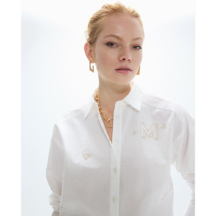 Camicia oversize con borchie dorate e disegni posizionati strategicamente.