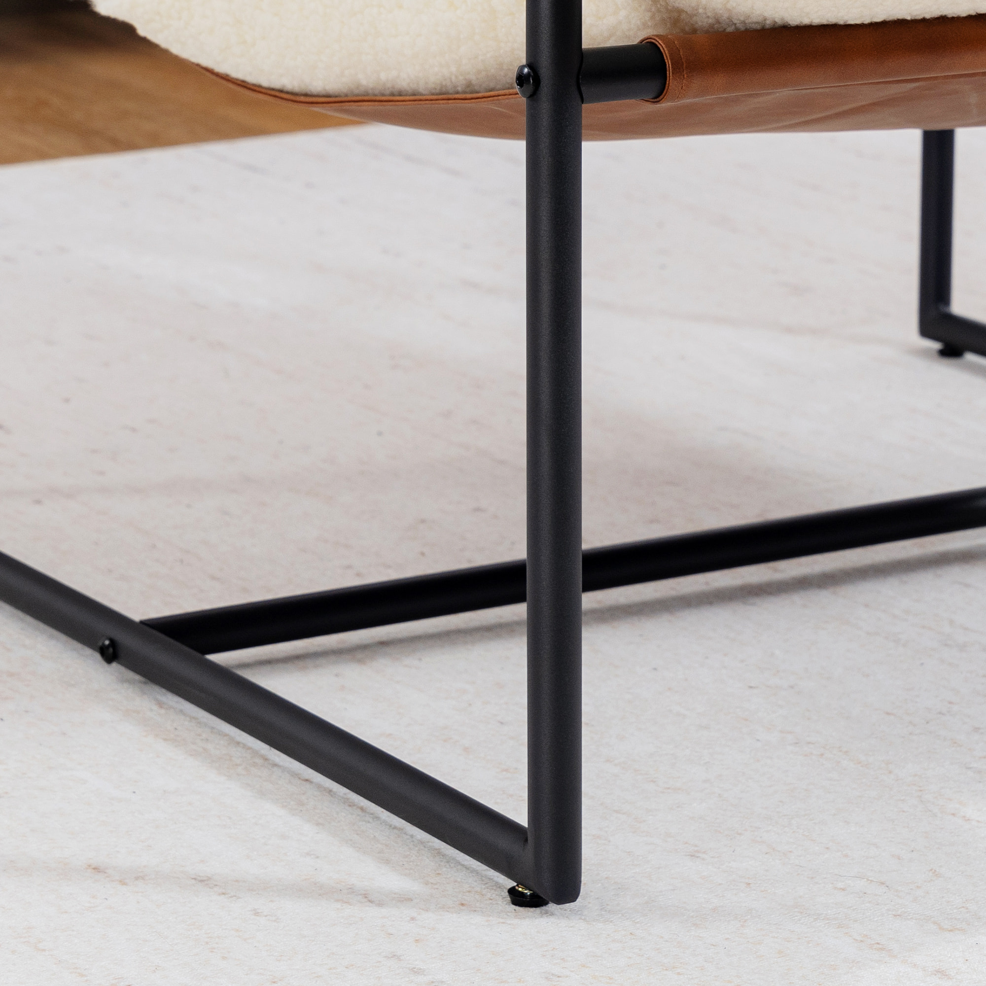 Fauteuil lounge design assise suspendue PU camel acier noir bouclette blanc cassé