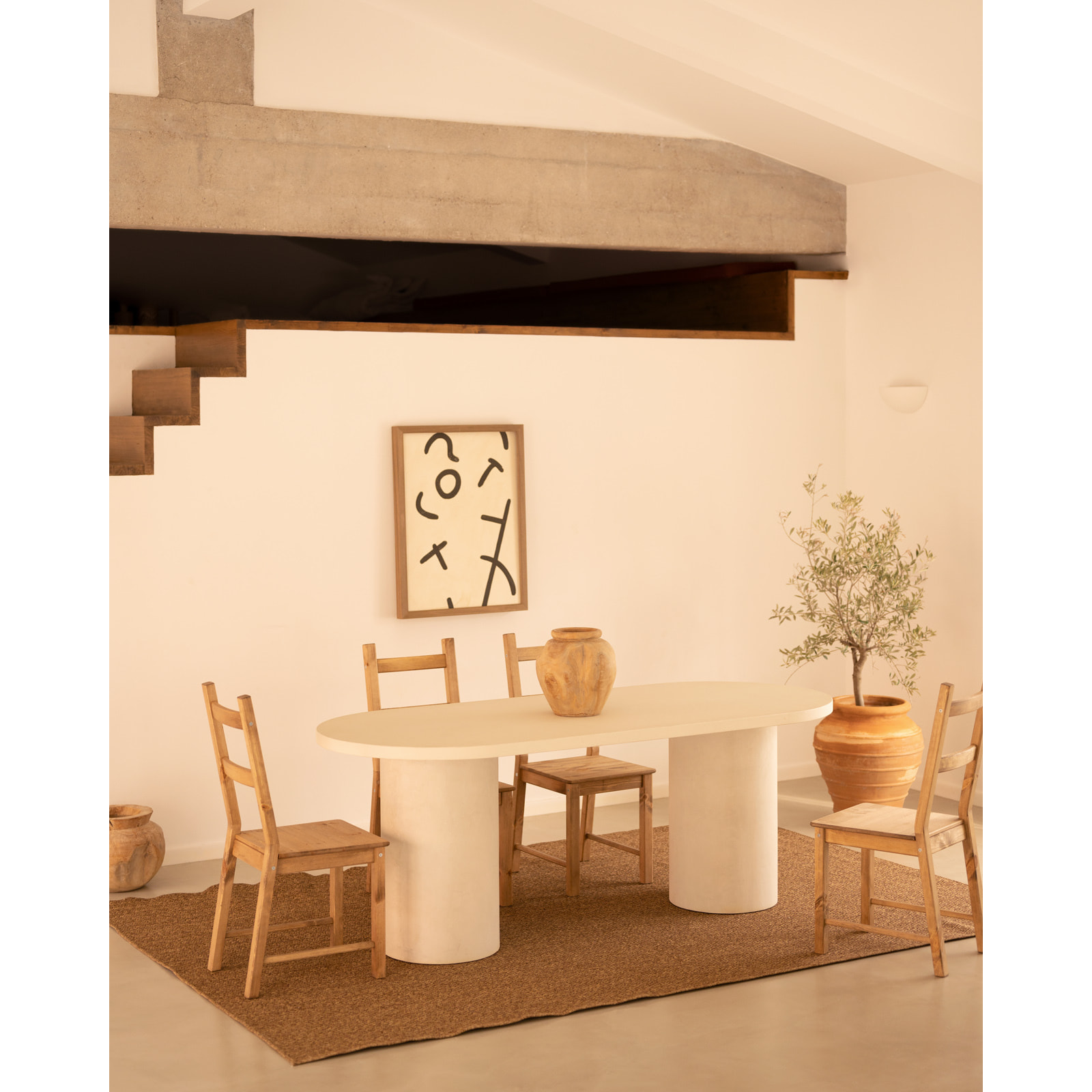 Table de salle à manger ovale en microciment de teinte blanc cassé disponible en différentes tailles