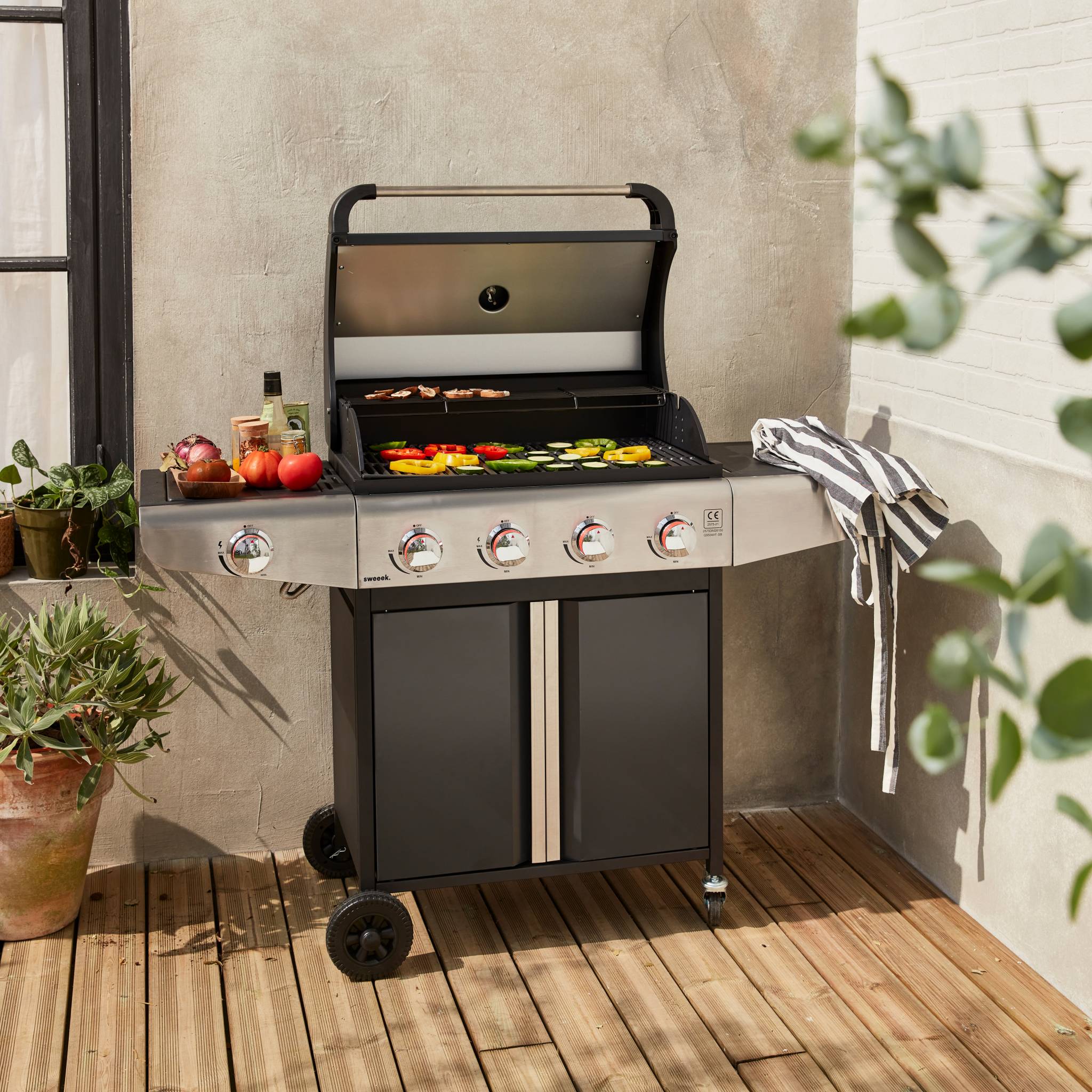 Barbecue au gaz - Bazin  Gris anthracite -  Cuisine extérieure 5 brûleurs dont 1 feu latéral avec tablettes et thermomètre. rangement. roues