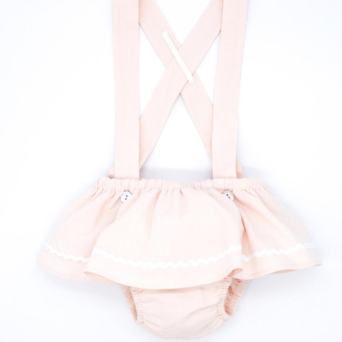Cubrepañal rosa, con tirantes y falda con picunela.