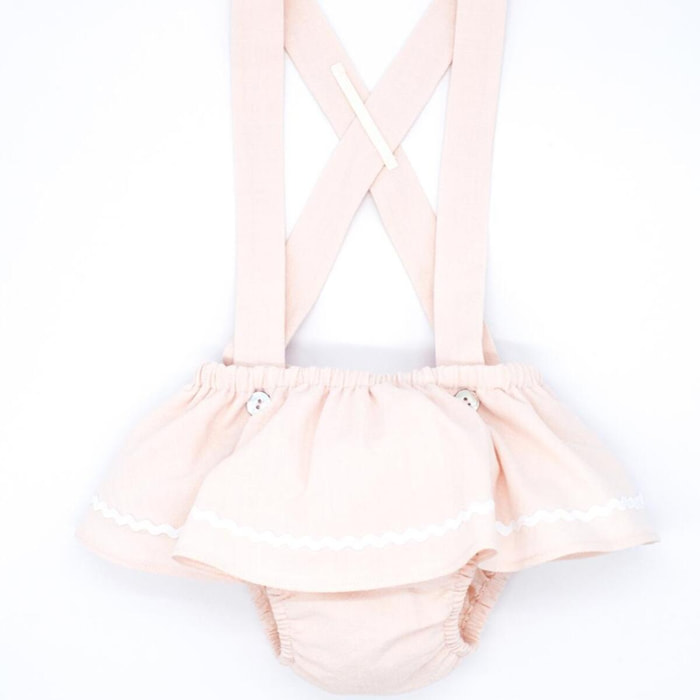 Cubrepañal rosa, con tirantes y falda con picunela.