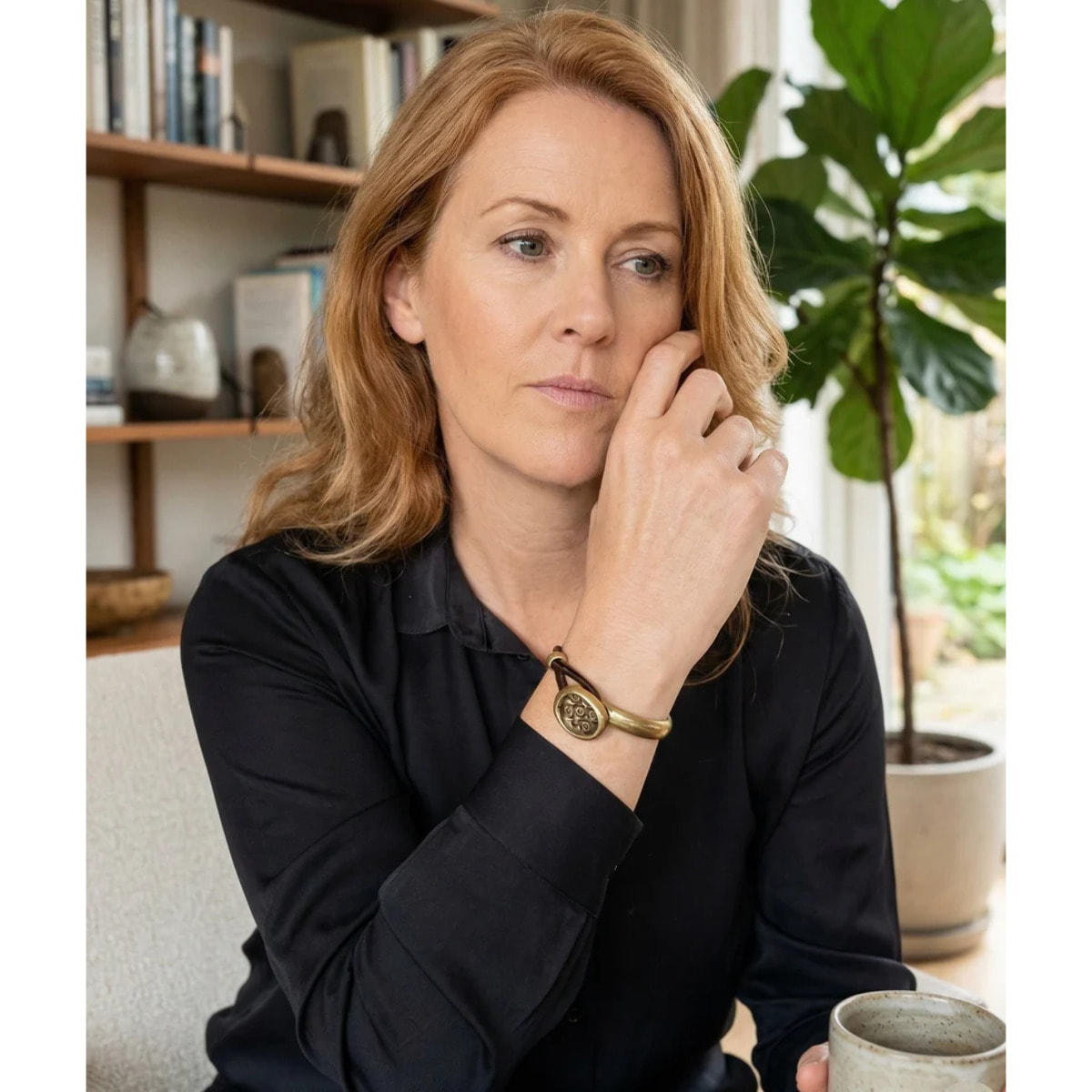 Pulsera media rá­gida en botón grabado y cuero marrón con metal dorado