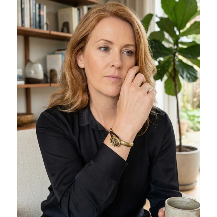 Pulsera media rá­gida en botón grabado y cuero marrón con metal dorado