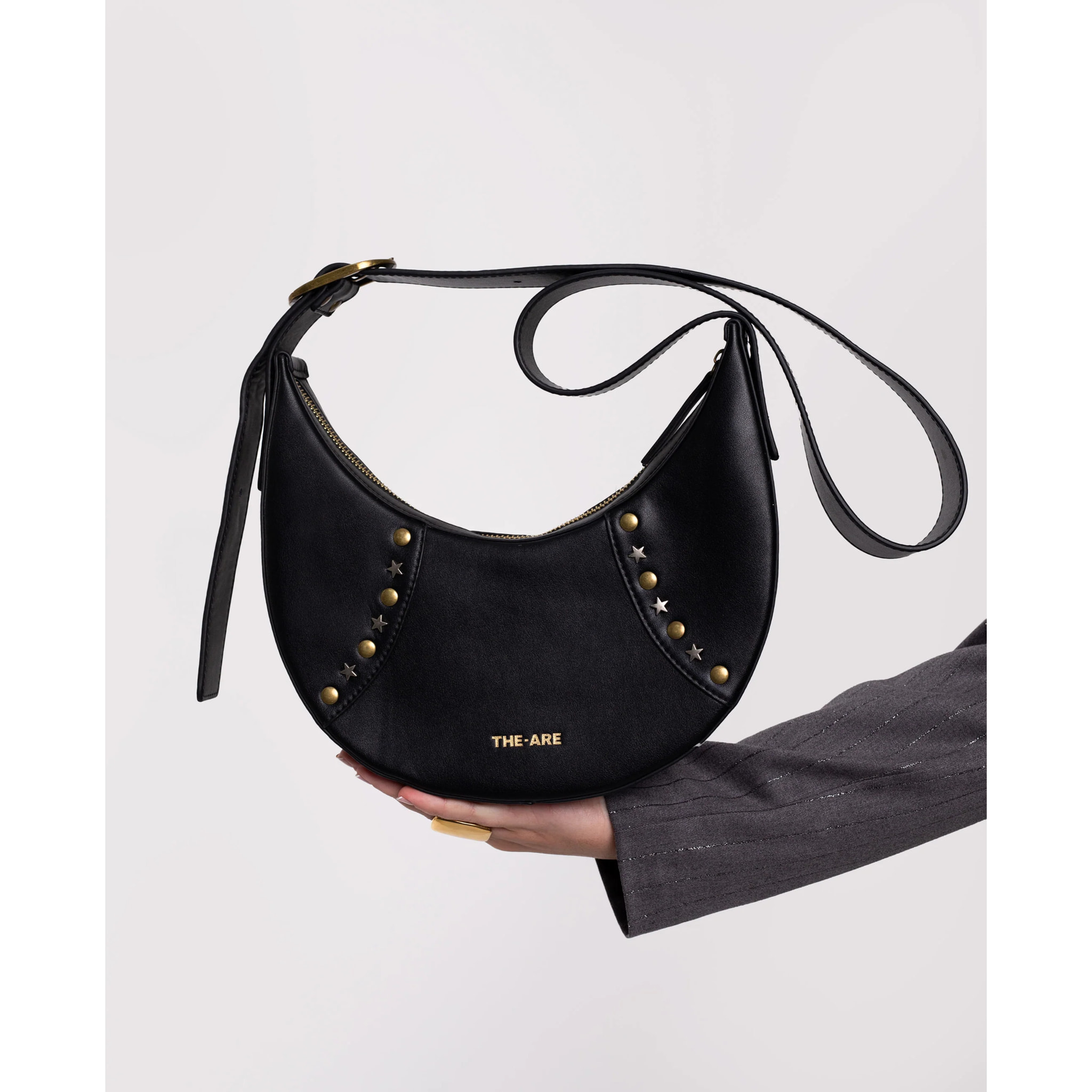 Bolso con forma de media luna y tachuelas