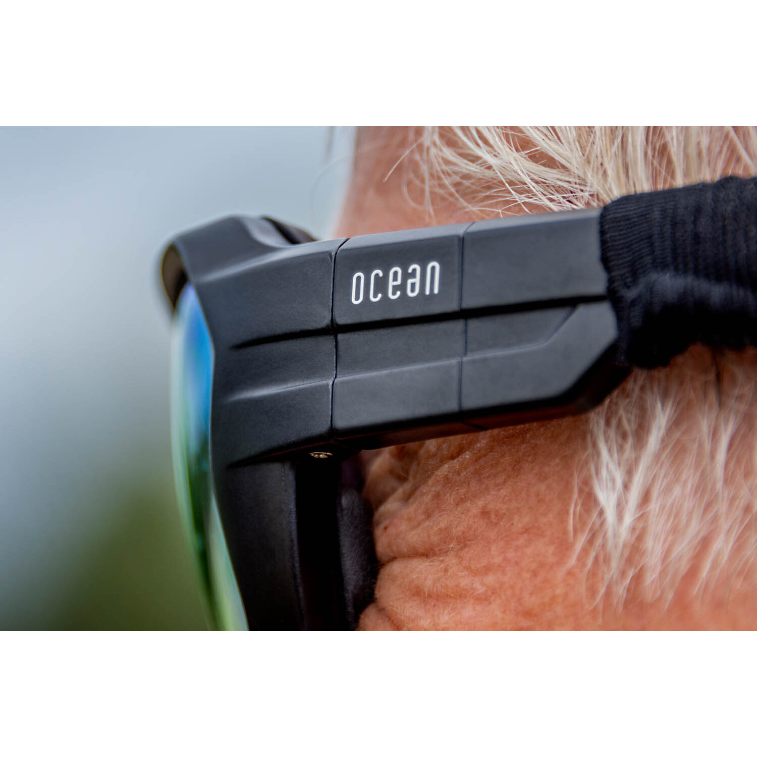 Gafas de deportes acuáticos OCEAN CHAMELEON - Negro mate / Revo azul con plaquetas puntas y espuma negras con correa negra