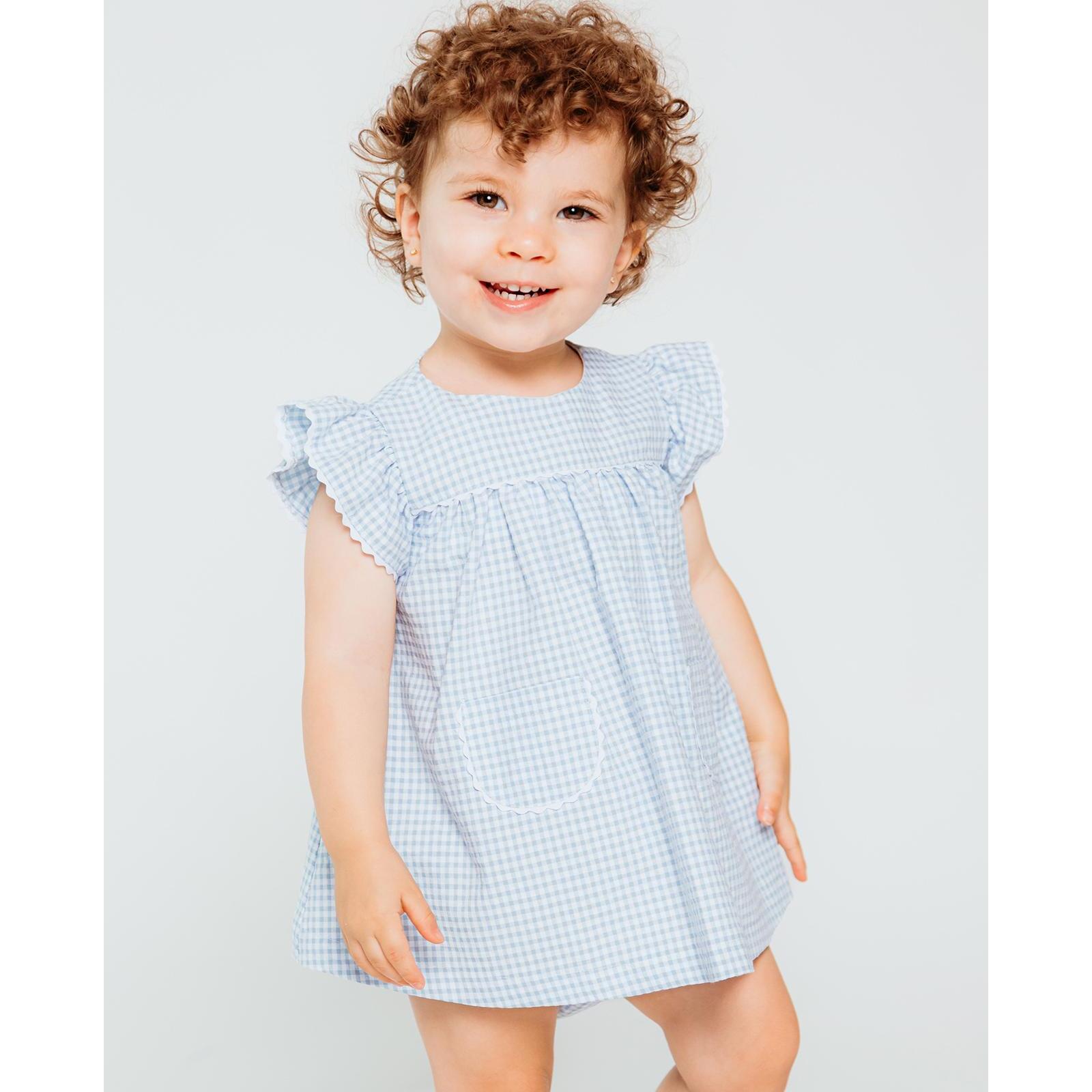 Vestido corto estampado de cuedro vichy azul, volantes en las sisas, bolsillos y falda fruncida.