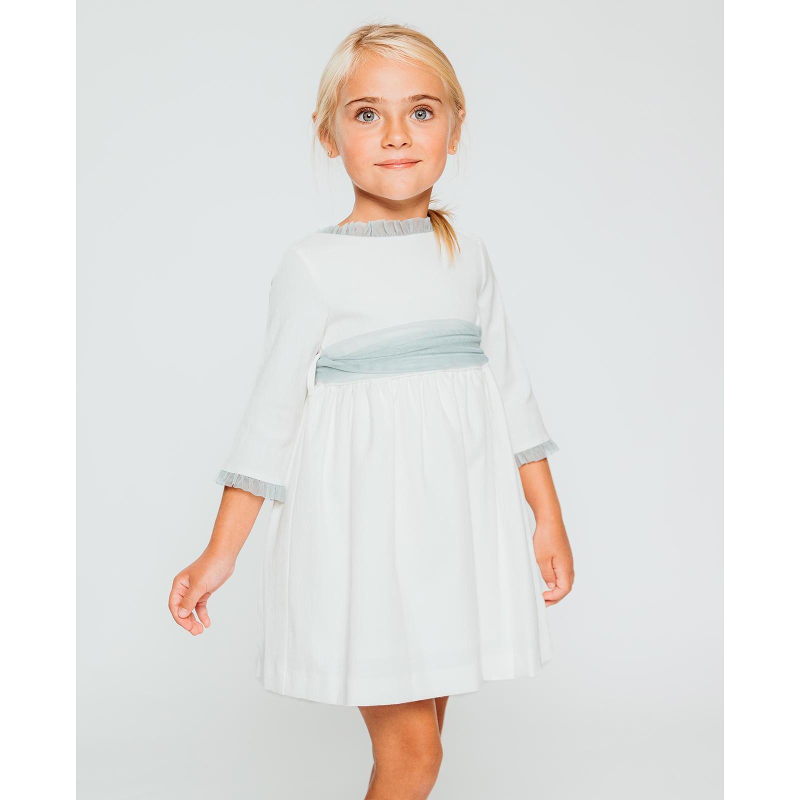 Vestido de pique blanco, con volantes en cuello y puños, y lazada en tul verde.