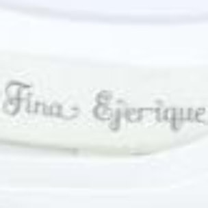 Camiseta blanca con volantes blancos bordados en las sisas.