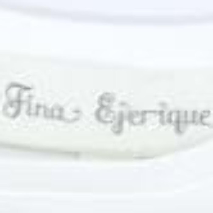 Camiseta blanca con volantes blancos bordados en las sisas.