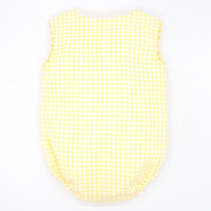Pelele de vichy amarillo. Con bolsillo y tapeta con botones en el delantero. Goma en las piernas.
