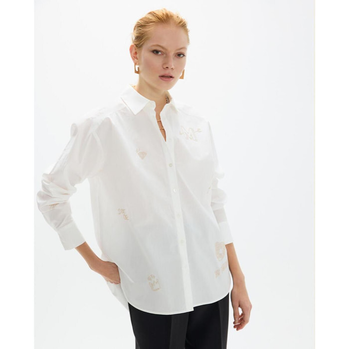 Camicia oversize con borchie dorate e disegni posizionati strategicamente.