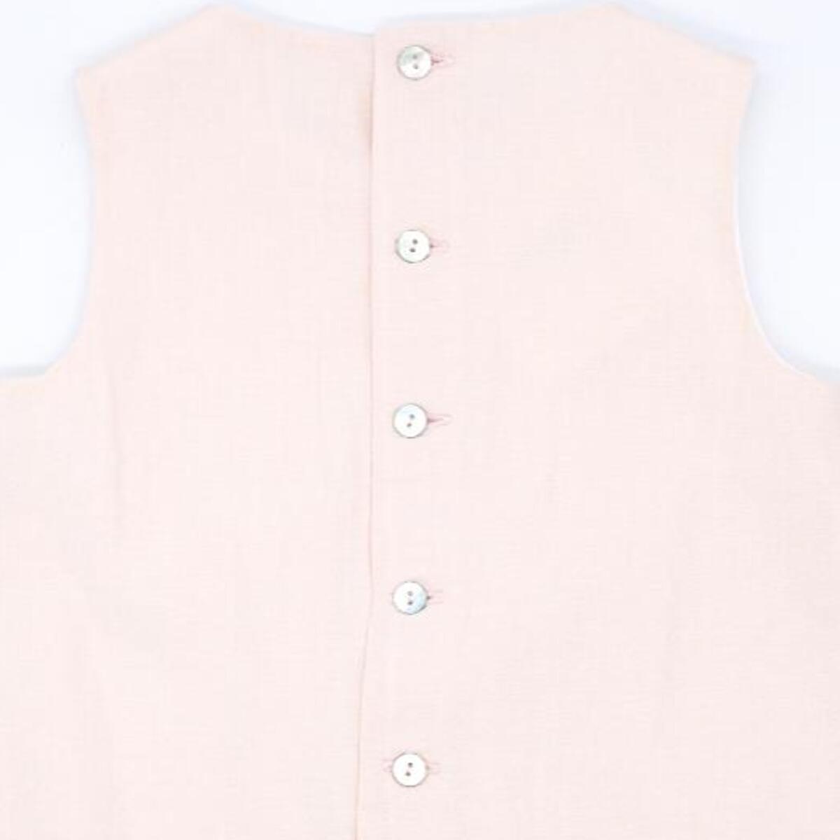 Vestido de lino rosa con pieza en el bajo blanca. Lorzas en la parte del pecho.