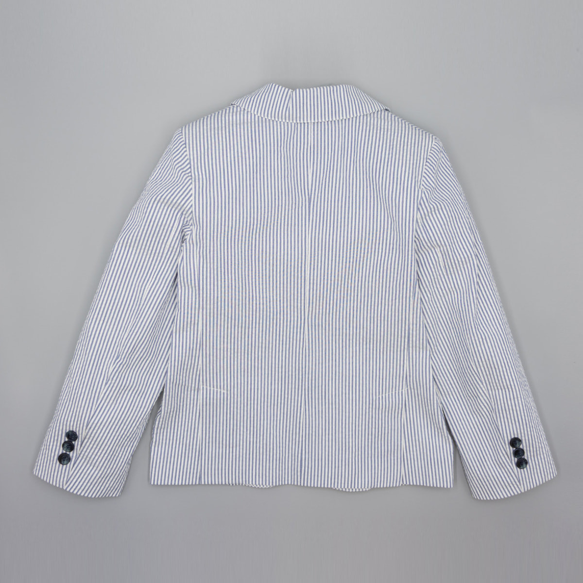 Blazer de rayas azul. Con tres bolsillos exteriores, botones en los puños y el centro.