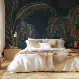 Papier peint tropical chic feuilles dorées fond bleu nuit Intissé