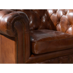Sillón Chester con reposabrazos con asiento y respaldo tapizados en piel de origen vacuno en marrón coñac patas de madera maciza tintada en caoba 120x94x79cm