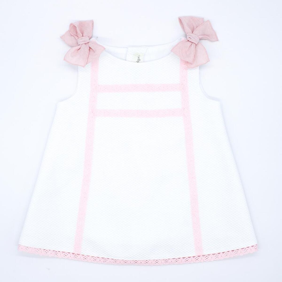 Vestido de piqué blanco con detalle de puntillas rosas.