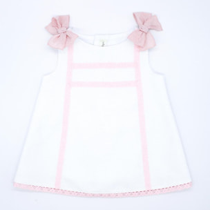 Vestido de piqué blanco con detalle de puntillas rosas.