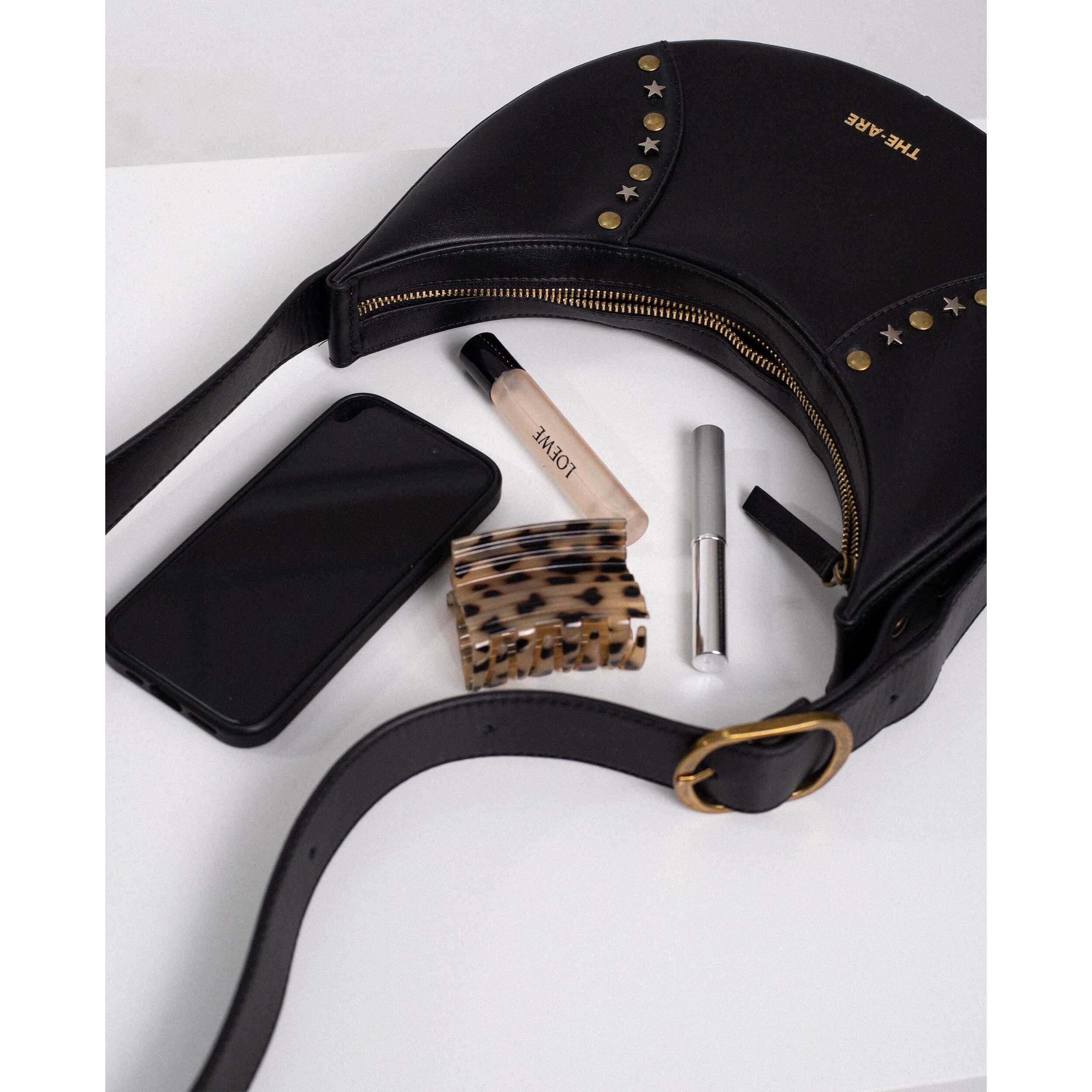 Bolso con forma de media luna y tachuelas
