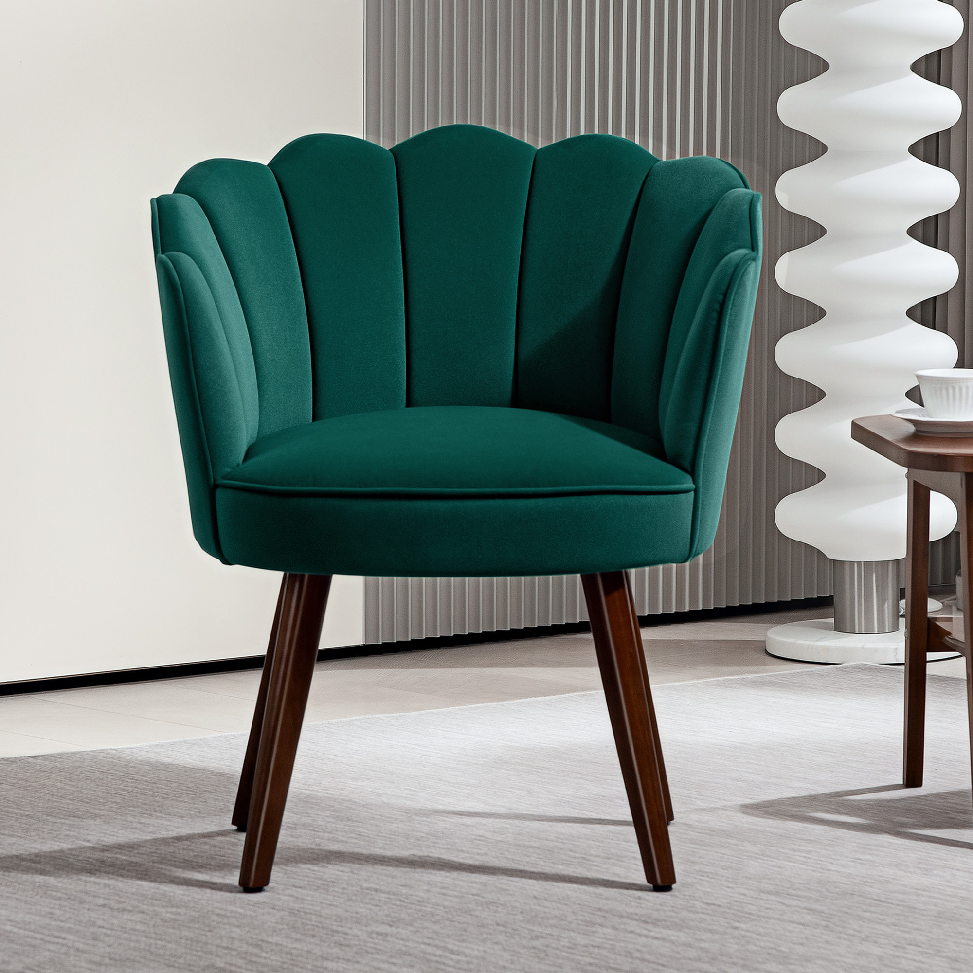 Fauteuil design coquillage piètement effilé bois d'hévéa dossier enveloppant strié aspect velours vert sapin
