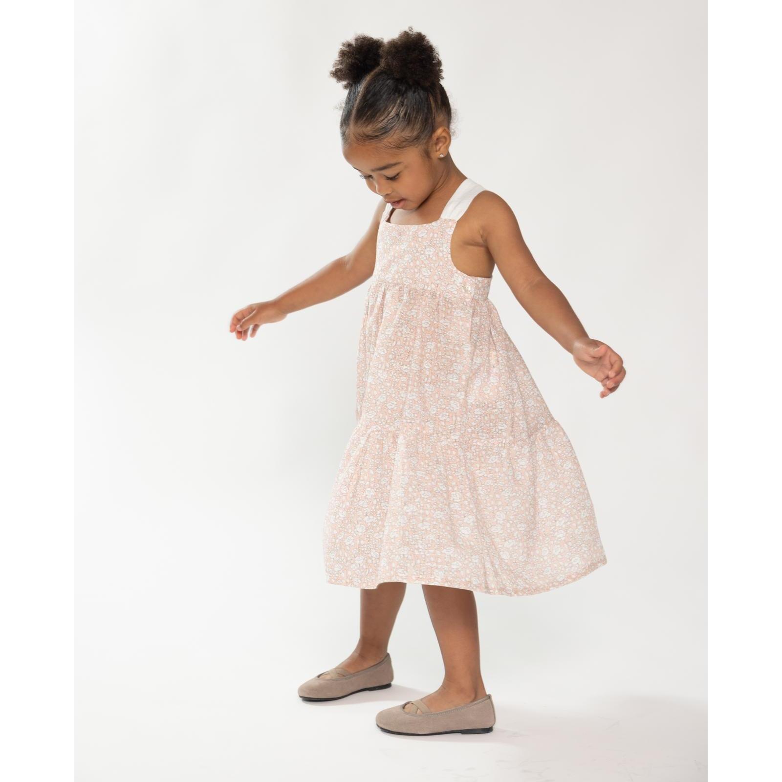 Vestido midi de flor rosa. Falda de volantes y tirantes cruzados en la espalda.