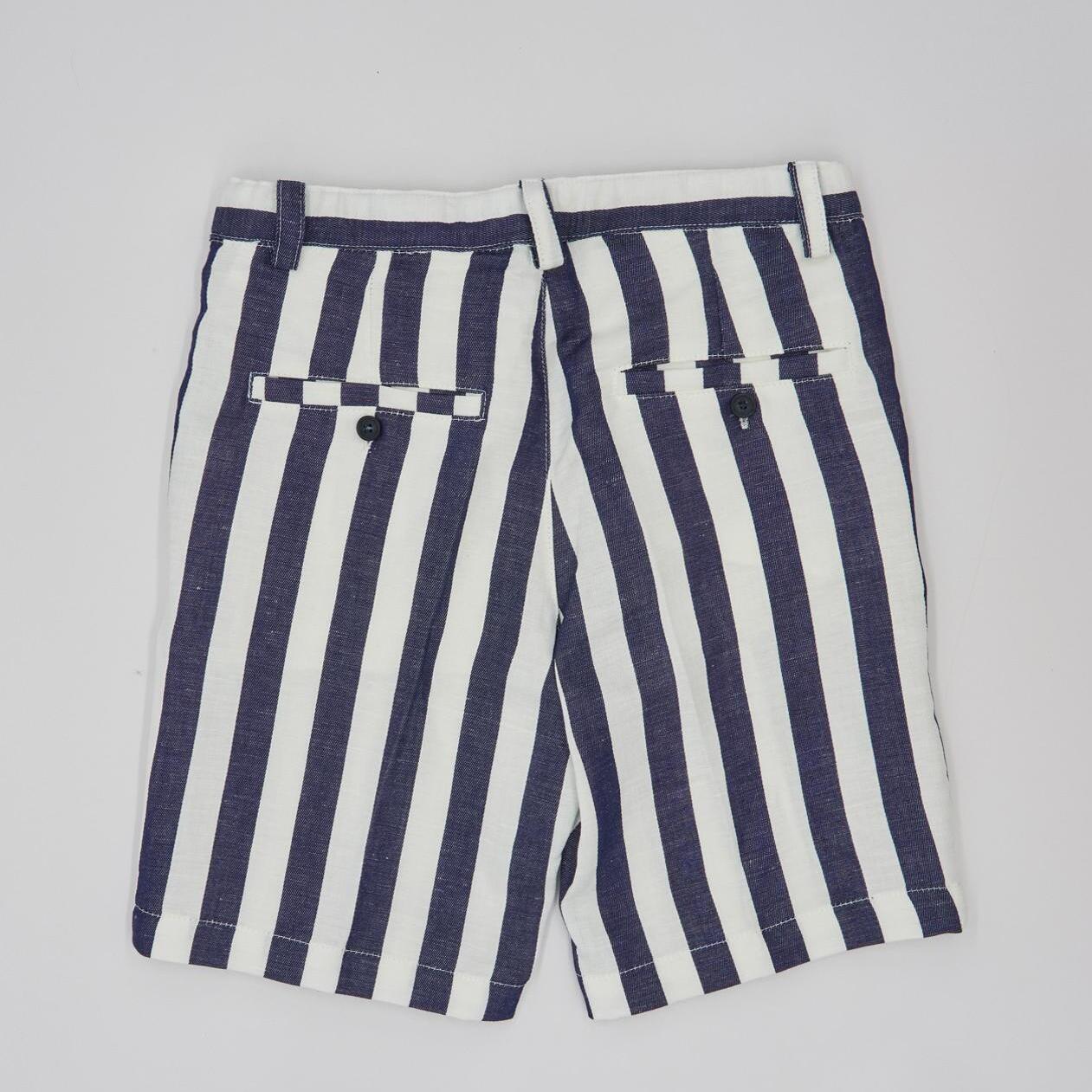 Bermuda de lino con rayas azul marino. Con bolsillos falsos y botones en la parte trasera y bragueta.