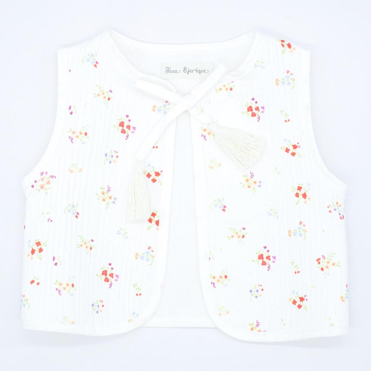 Chaleco crudo con flor roja, cinta para atar en el delantero.