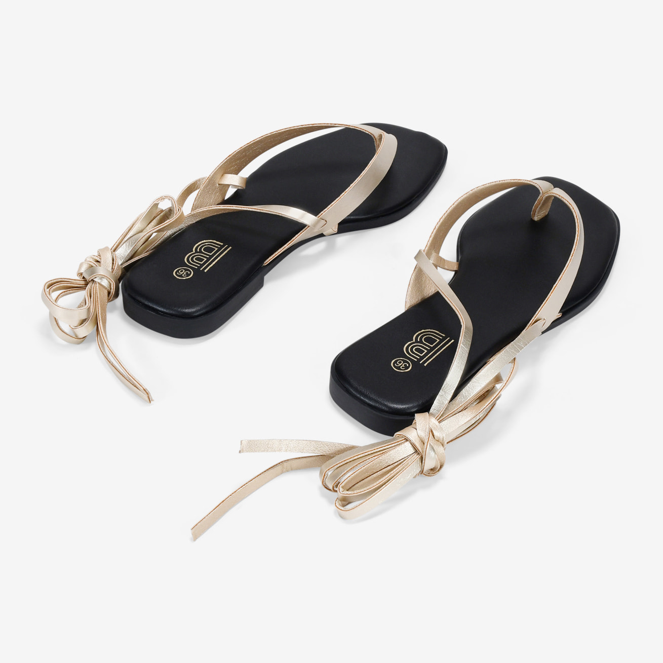 Sandalias de dedo doradas con tiras atadas