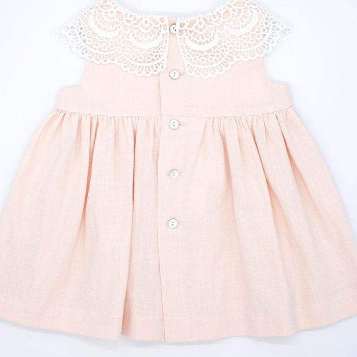 Vestido corto rosa, falda fluncida y cuello de guipur blanco.