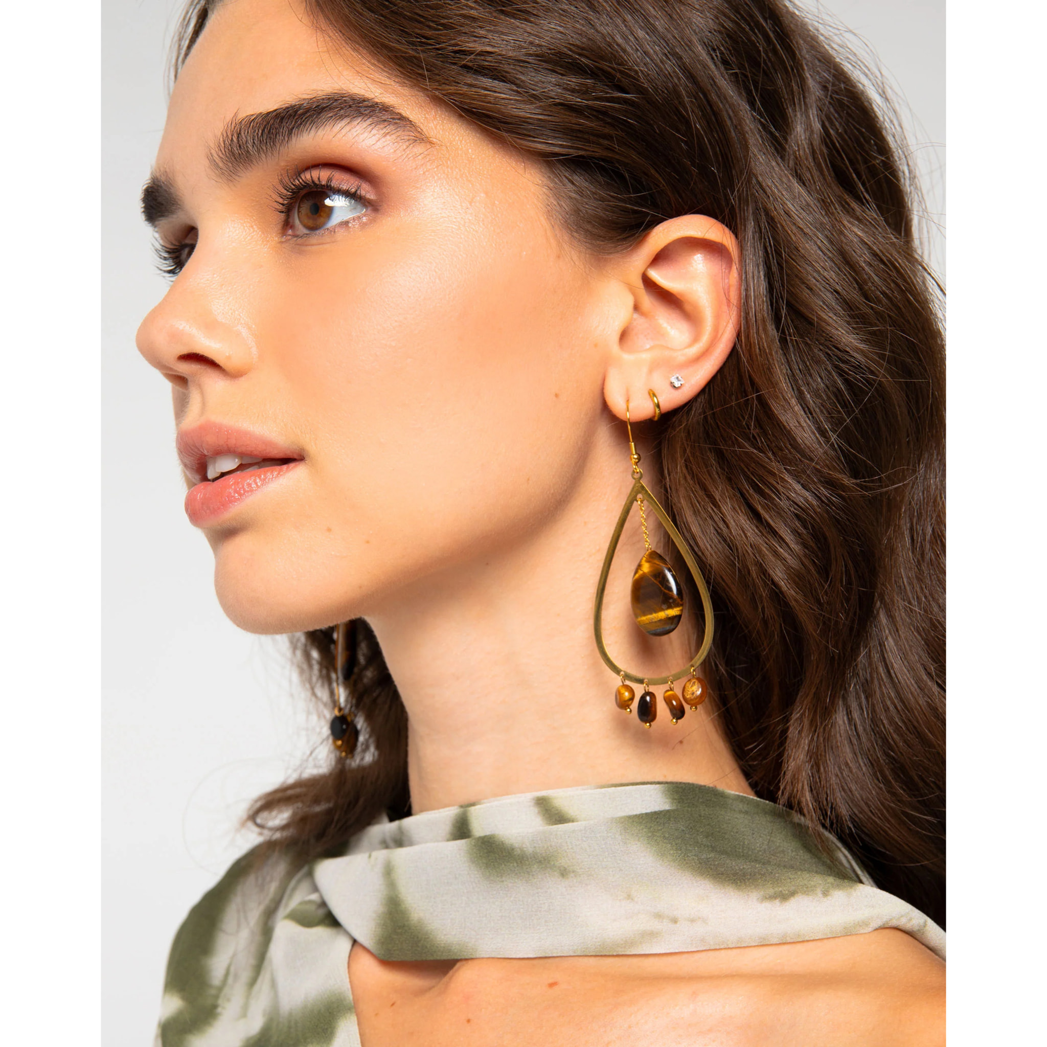 Pendientes largos dorados en forma de gota con piedras naturales marrón.