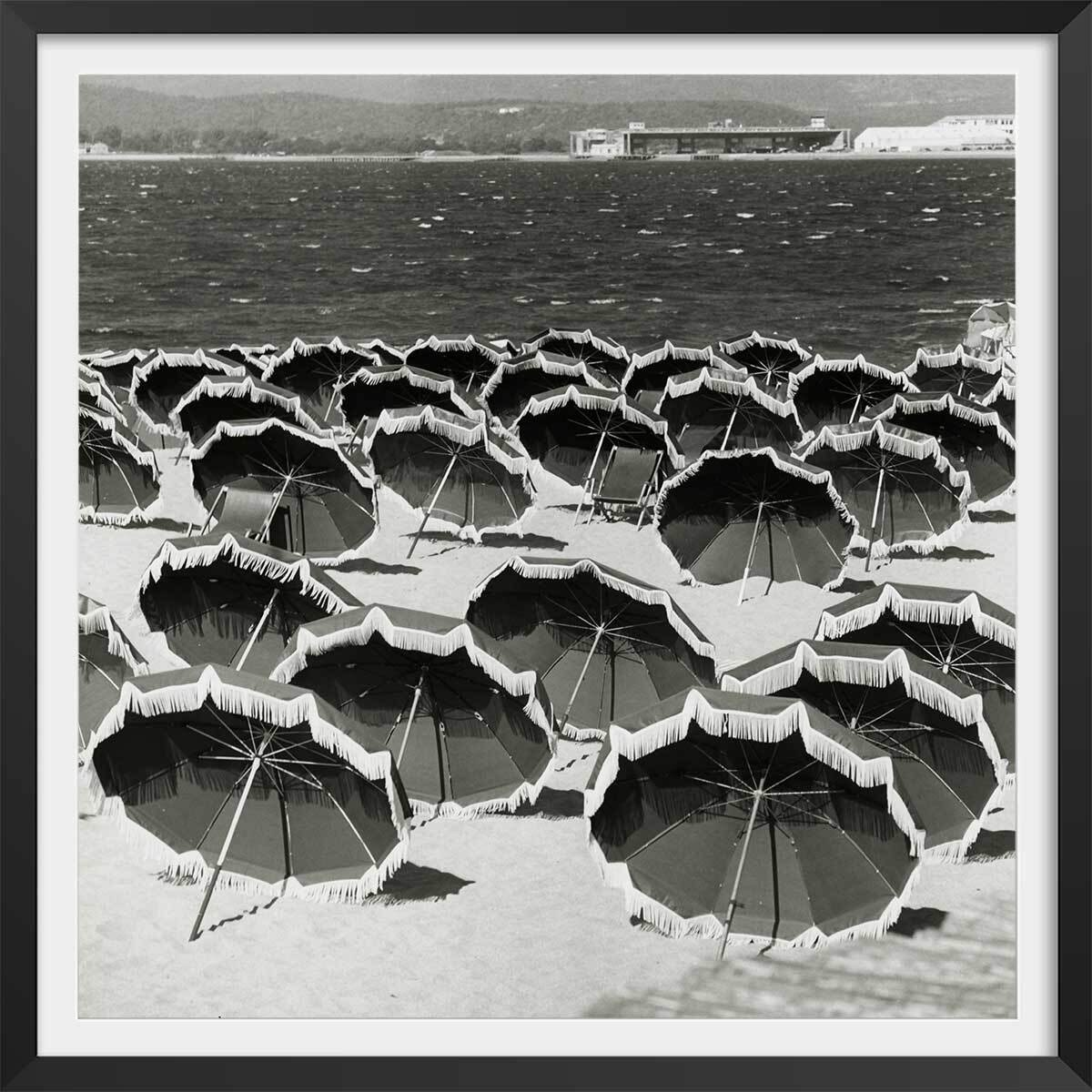 Affiche Photo d'Art - sun Umbrellas on a Beach, 1960 Affiche + cadre en bois - Noir