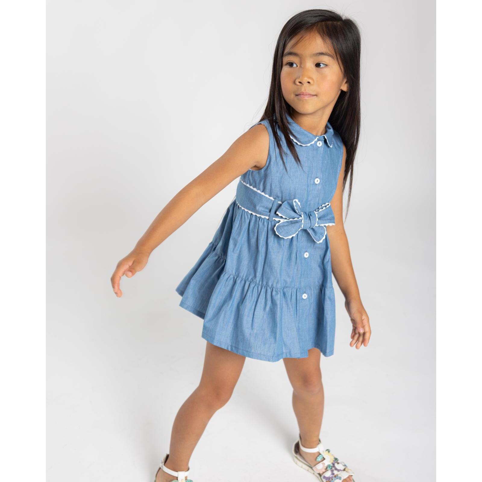 Vestido camisero azul. Falda de volantes, cuello y cinturon terminado en picunela. Botones en el centro.