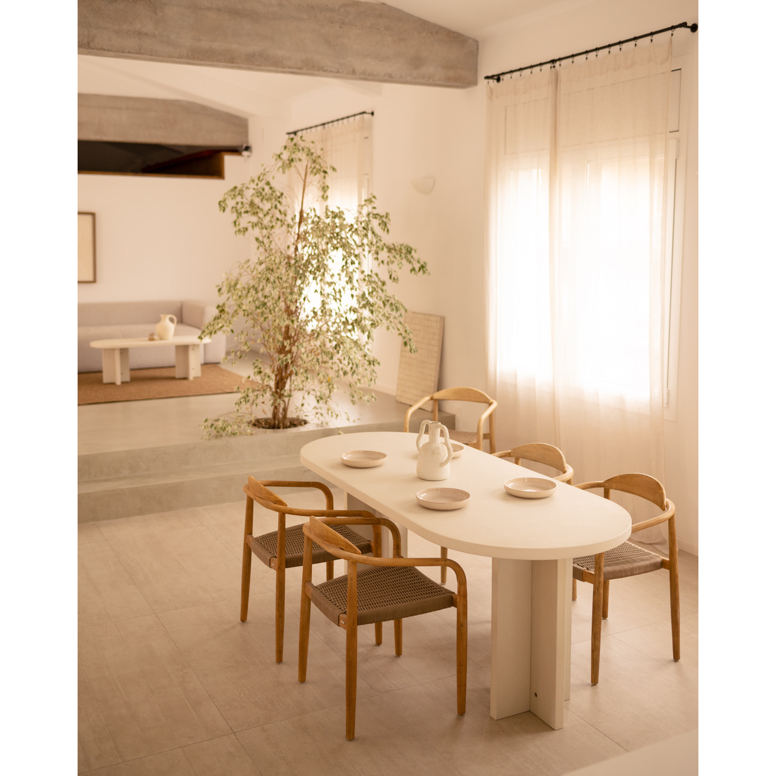 Table de salle à manger ovale en microciment de teinte blanc cassé disponible en différentes tailles