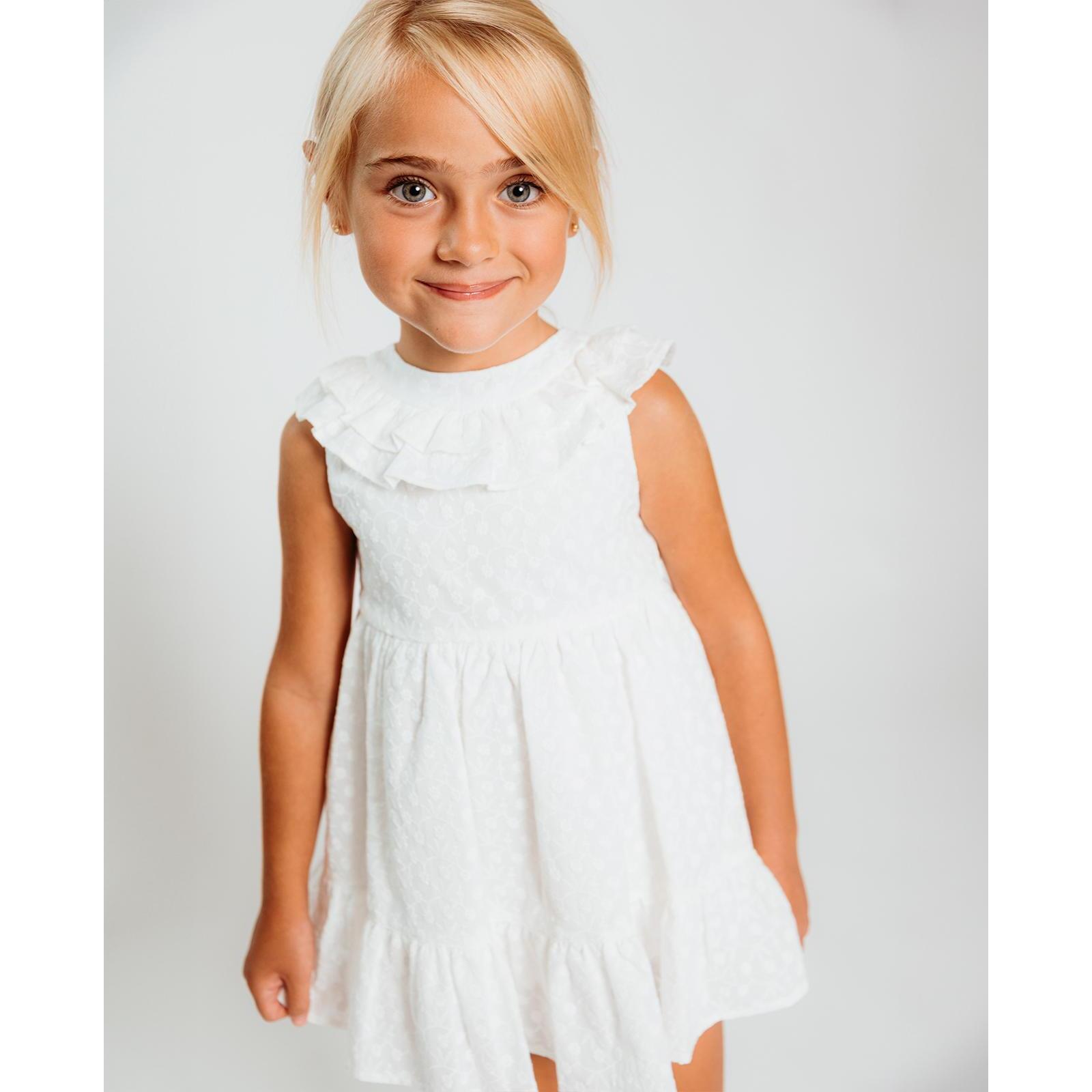 Vestido de voile bordado blanco. De tirantes con doble volante en el cuello, falda fruncida con volante.