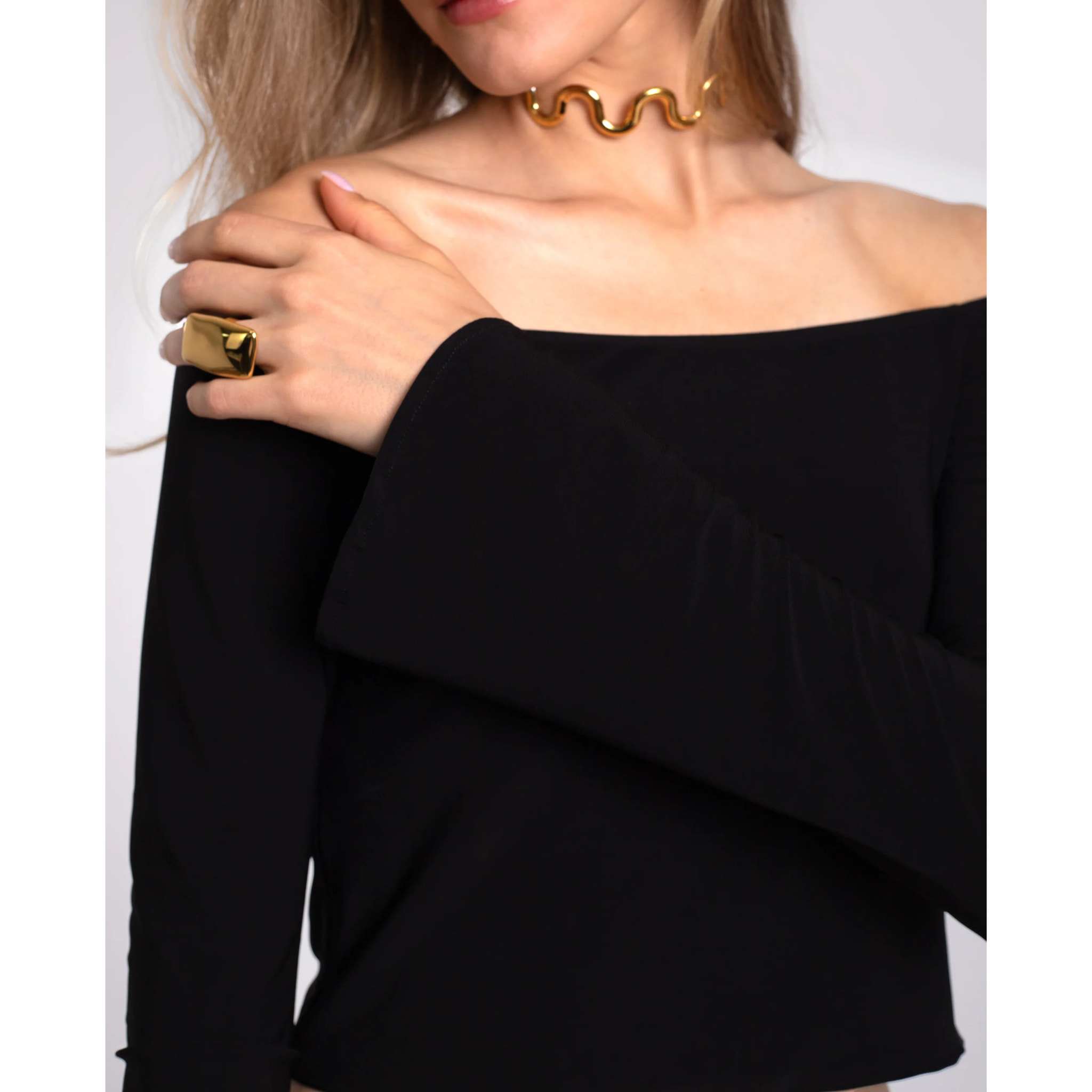 Top de manga larga con hombros al descubierto.