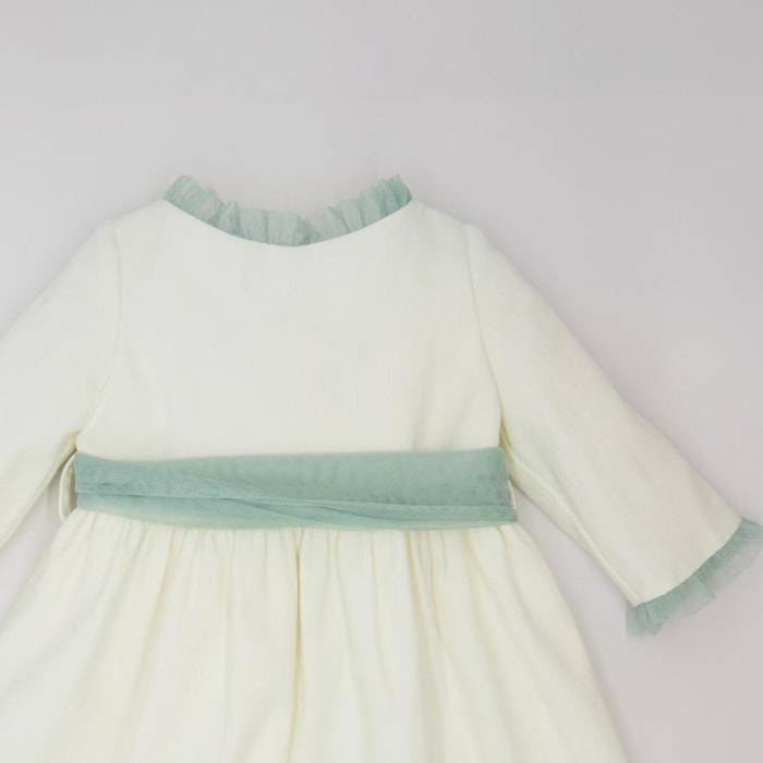 Vestido de pique blanco, con volantes en cuello y puños, y lazada en tul verde.