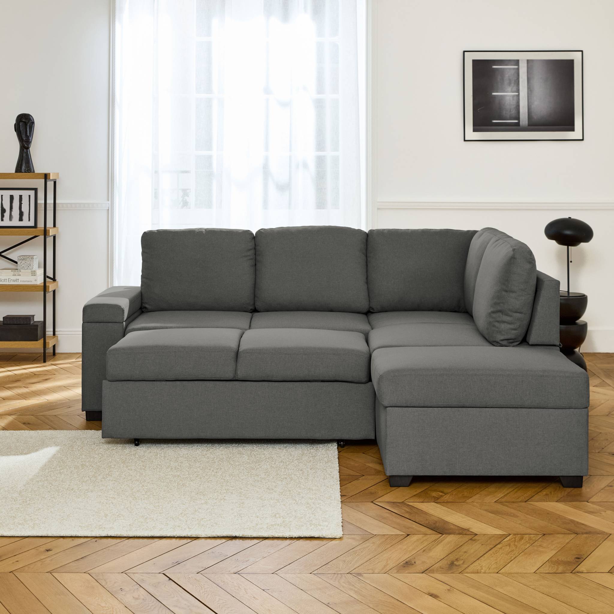 Canapé d'angle convertible. 3 places en tissu gris foncé avec pouf