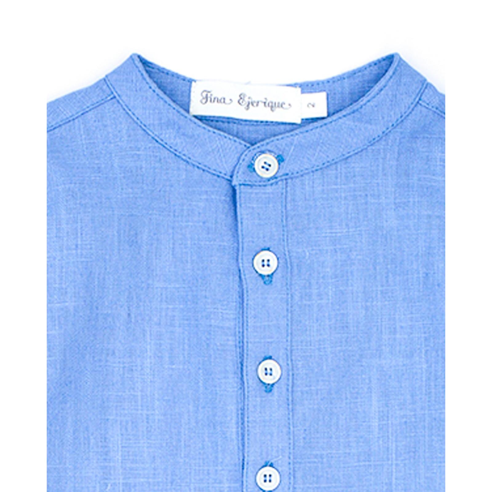 Camisa de lino azul. Cuello mao y tapeta con botones en el centro.