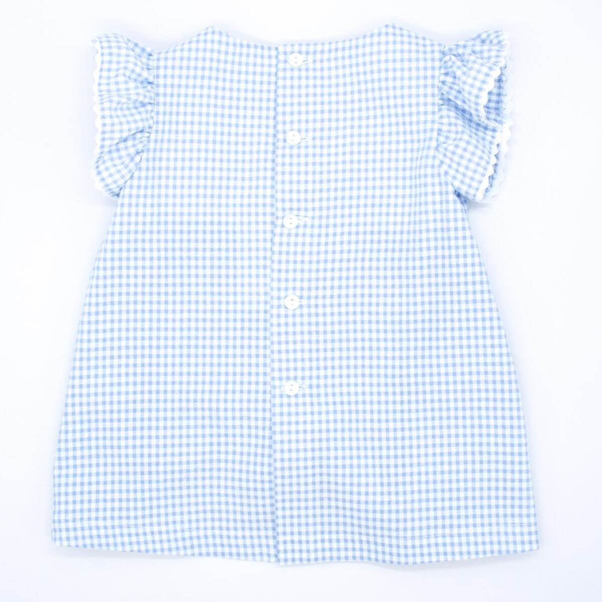 Vestido corto estampado de cuedro vichy azul, volantes en las sisas, bolsillos y falda fruncida.