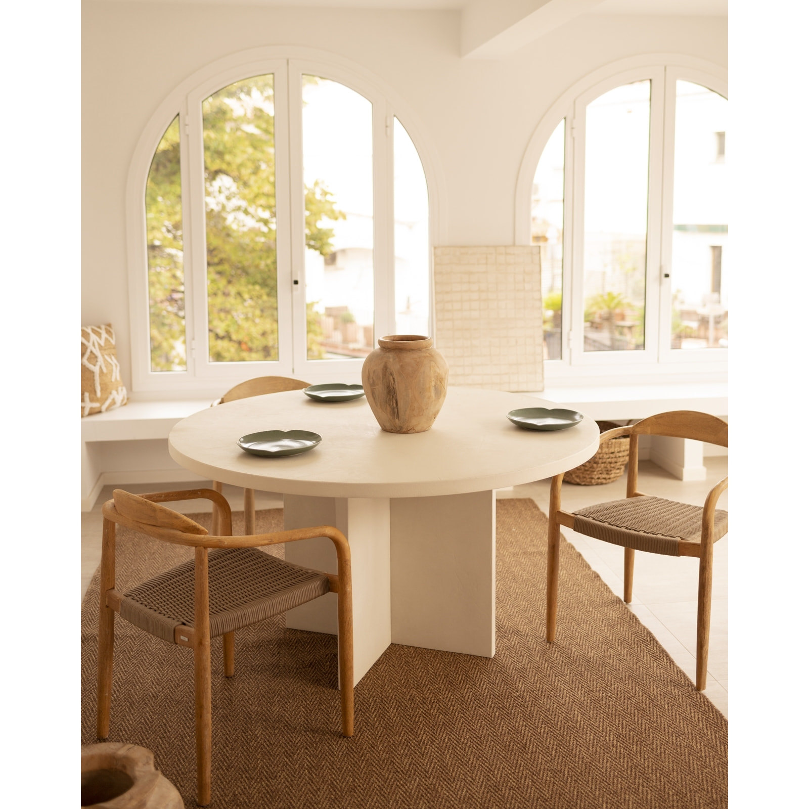 Table de salle à manger ronde en microciment de teinte blanc cassé disponible en différentes tailles