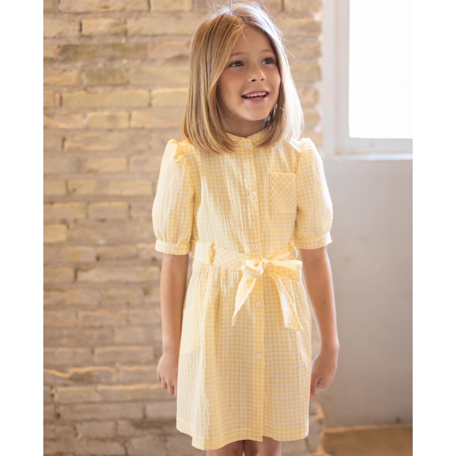 Vestido de manga corta de cuadros vichy amarillos. Bolsillos, cuello y cinturon. Botones en el centro.